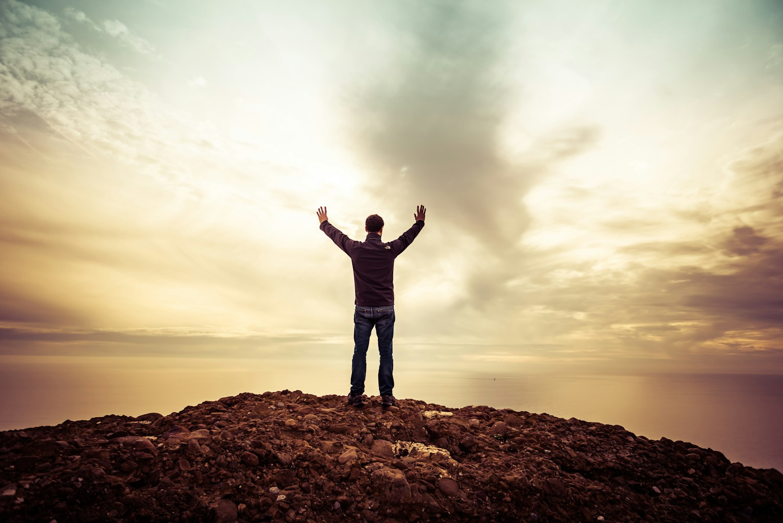 man standing under orange sky